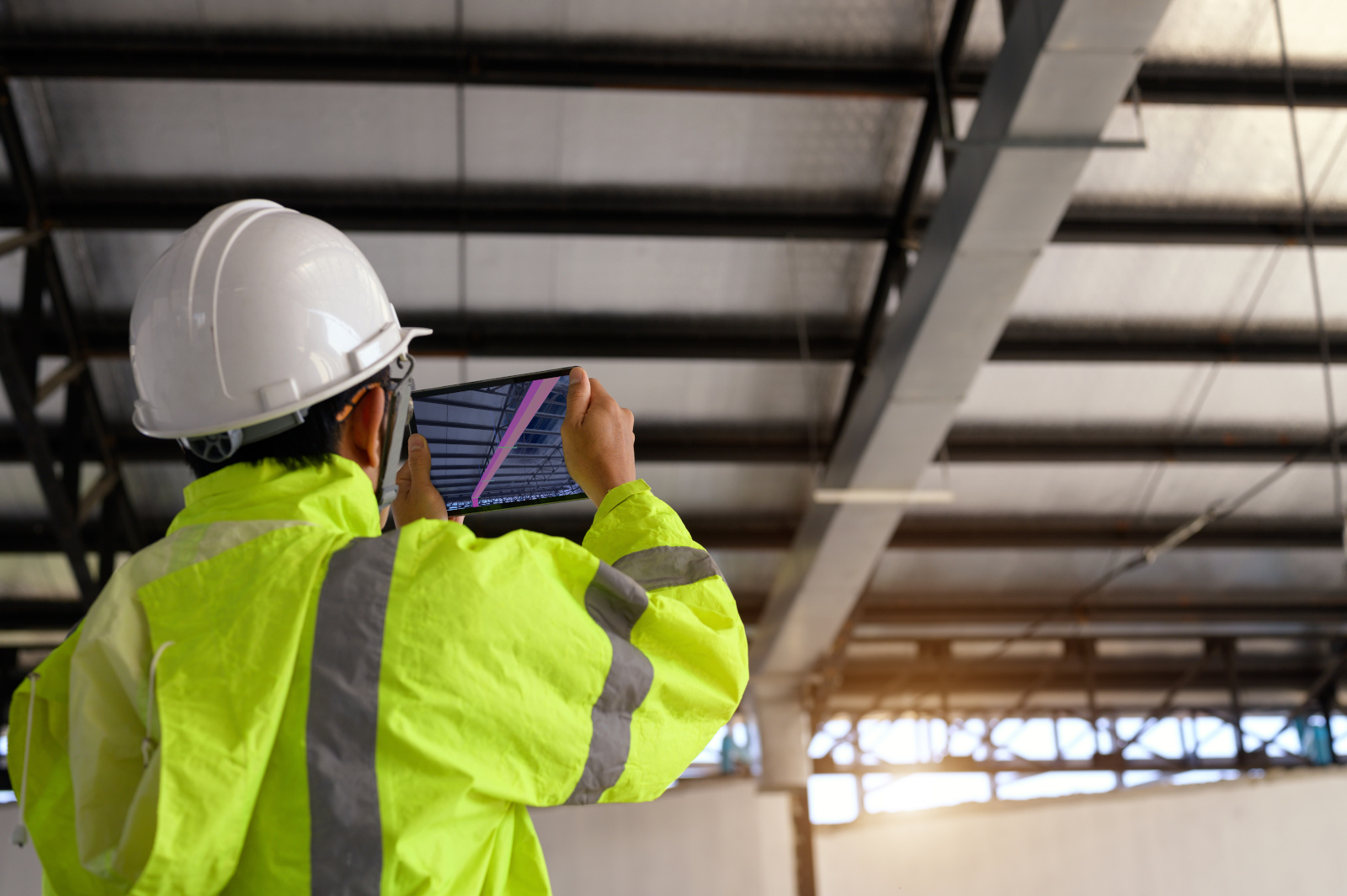 Building inspector taking image of ceiling, working from a Snag list form created for end-of-build checklists with NestForms 