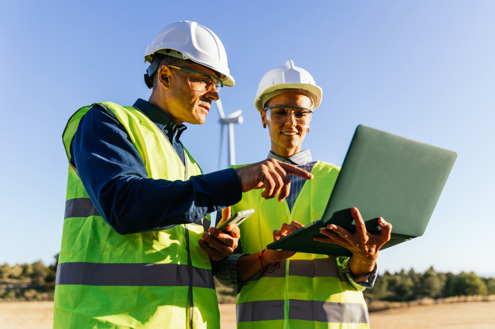 Two engineers working from a final inspection checklist on a sustainable energy wind turbine site: NestForms offline surveys