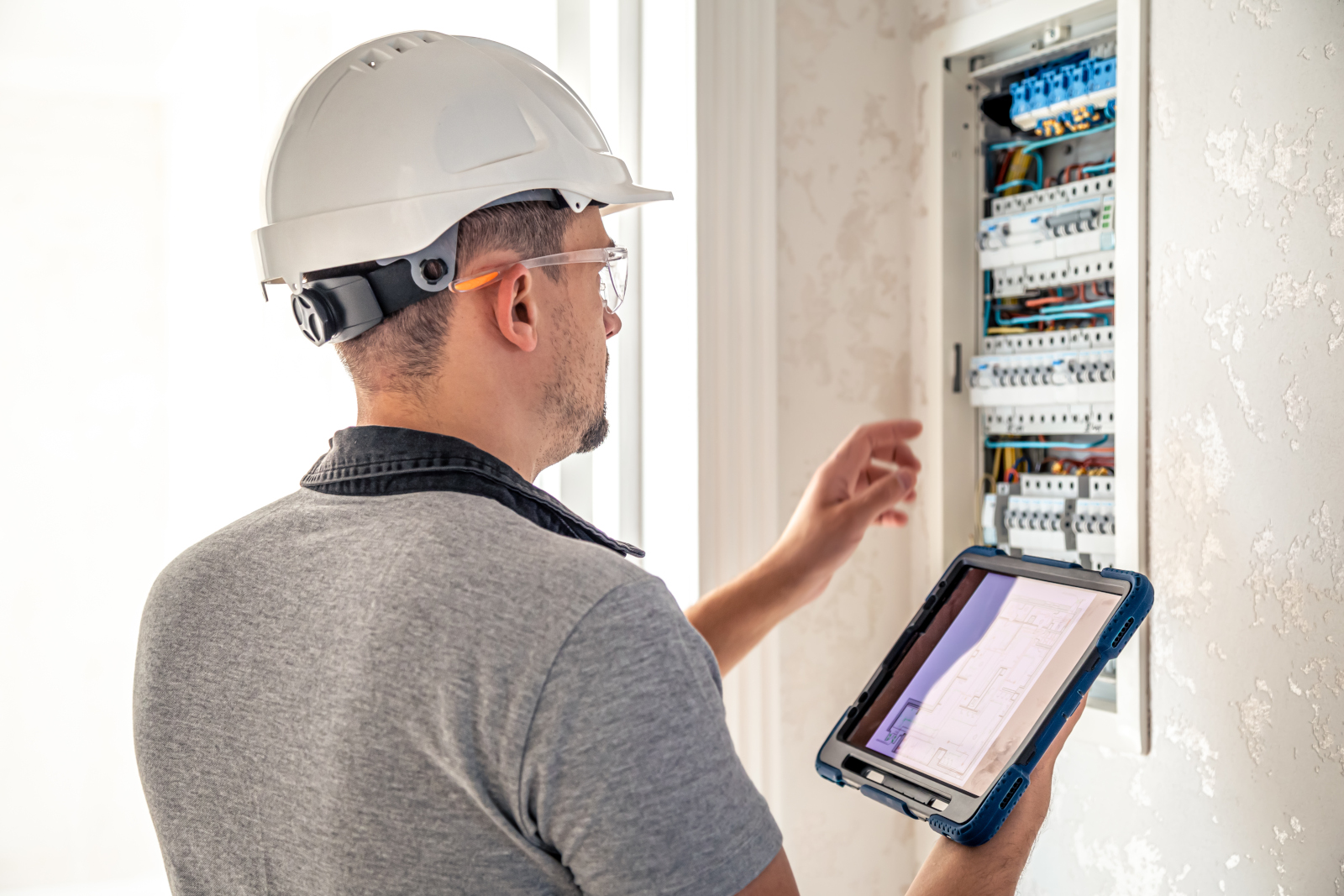 Engineer installing domestic circuit breaker panel: The NestForms Mobile App for Installation checklists and final inspection