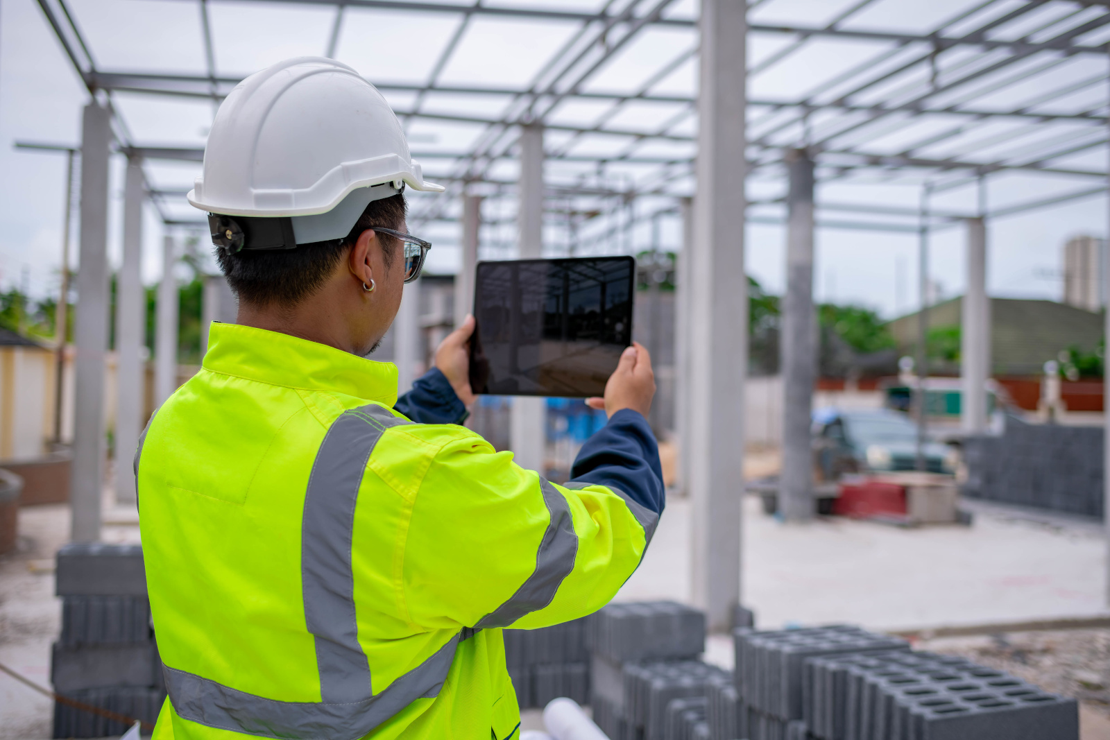 Construction worker with smart device taking an image on-site: The NestForms mobile data collection app