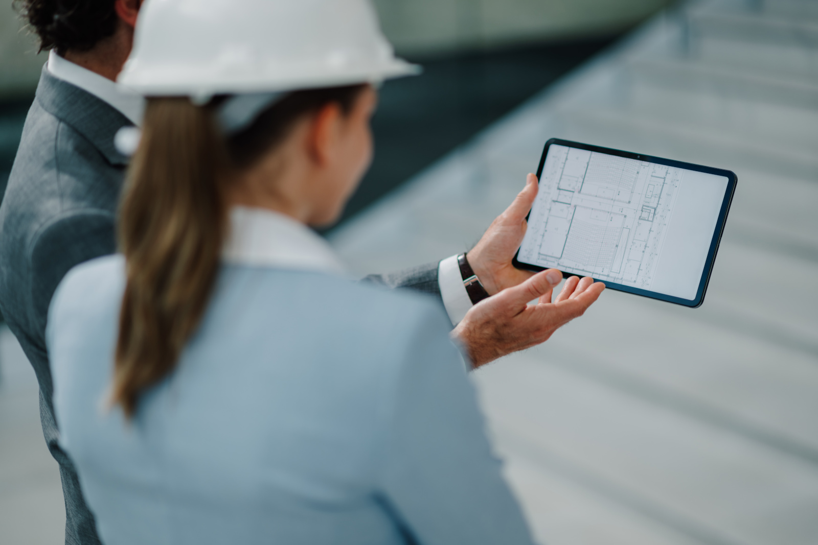 Architect and construction engineer with tablet carrying out a project handover: NestForms Project Handover Checklist