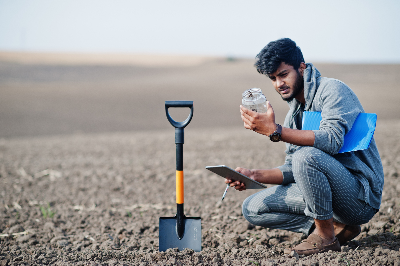 Asian agronomist in a field using smart device to analyse soil: the NestForms Form Builder App