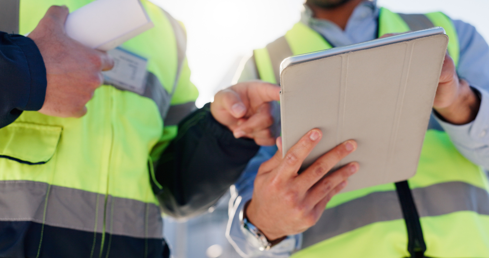 Two construction inspectors in safety vests sharing a tablet and working offline: The NestForms offline survey app