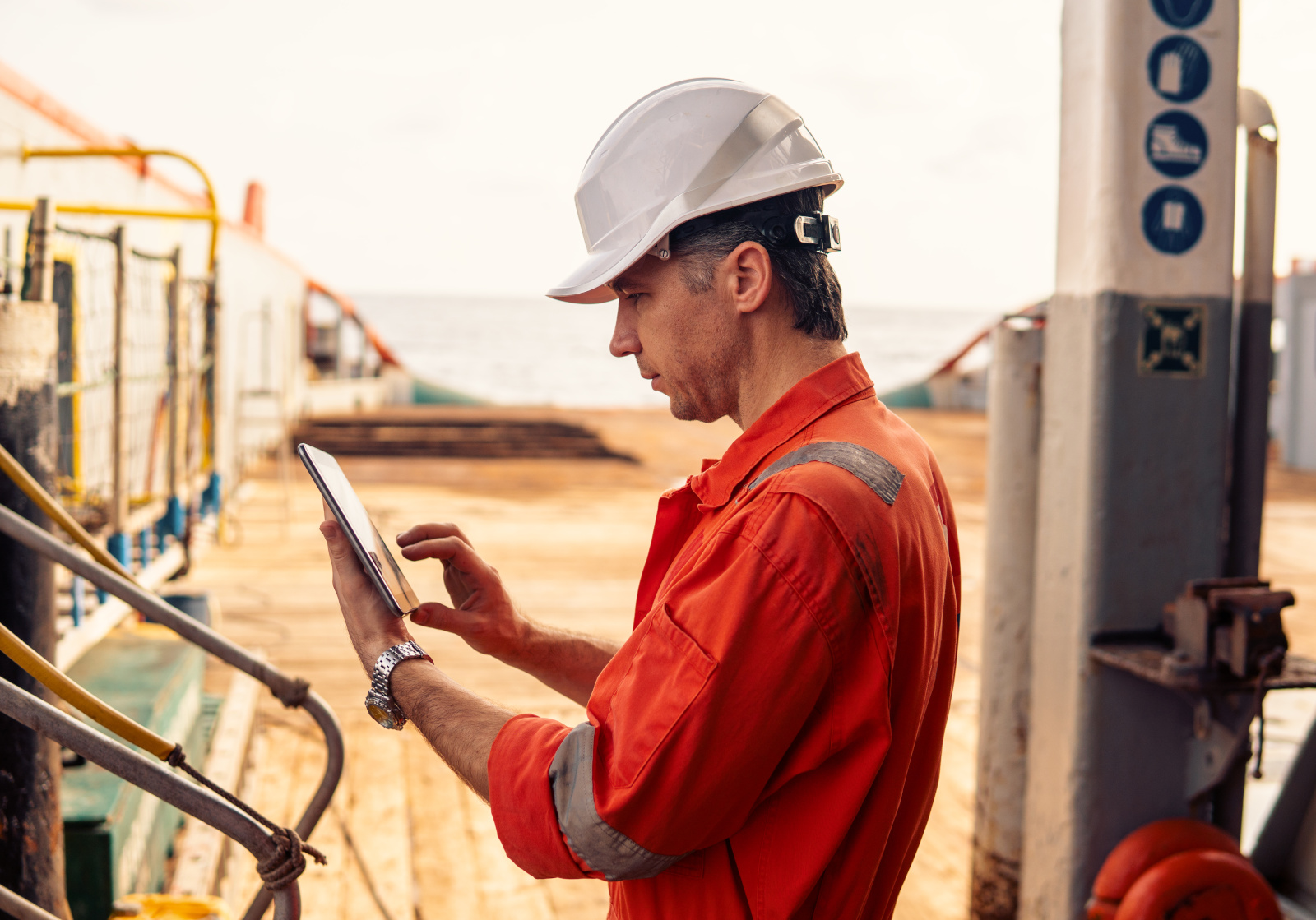 Construction worker onsite in safety gear carrying out an inspection on machinery: NestForms mobile data collection app