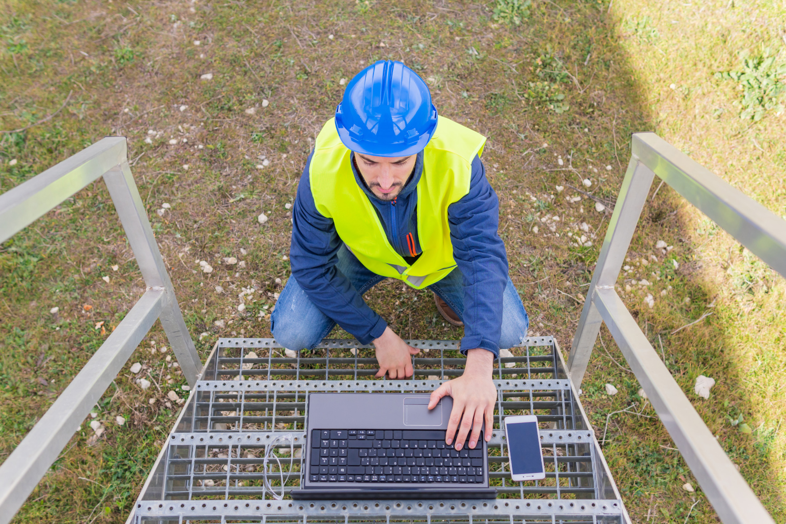 Construction Supervisor Using Laptop on Outdoor Staircase