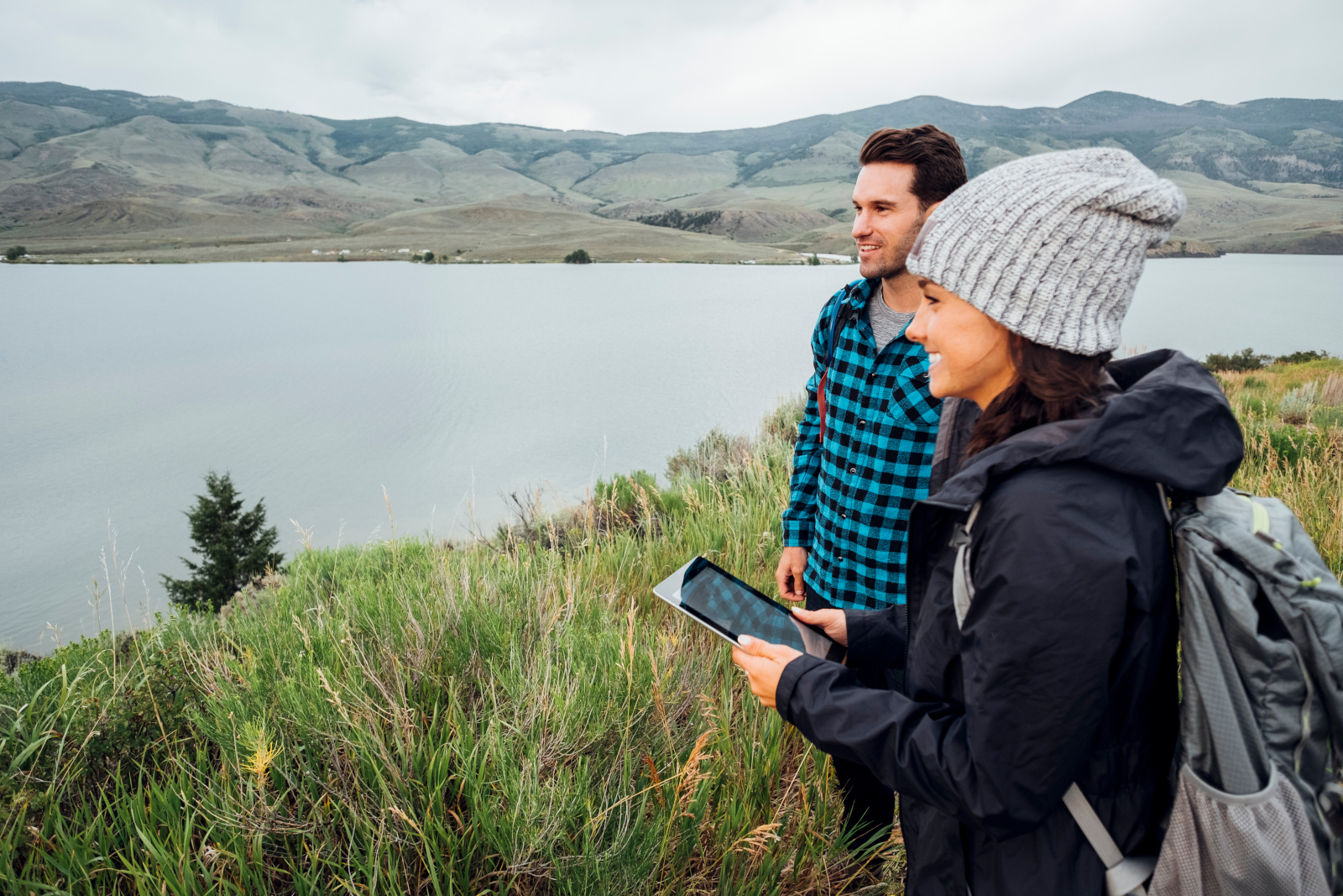 Image of a woman interviewing a man with smart device standing beside a lake: the NestForms Offline Survey App