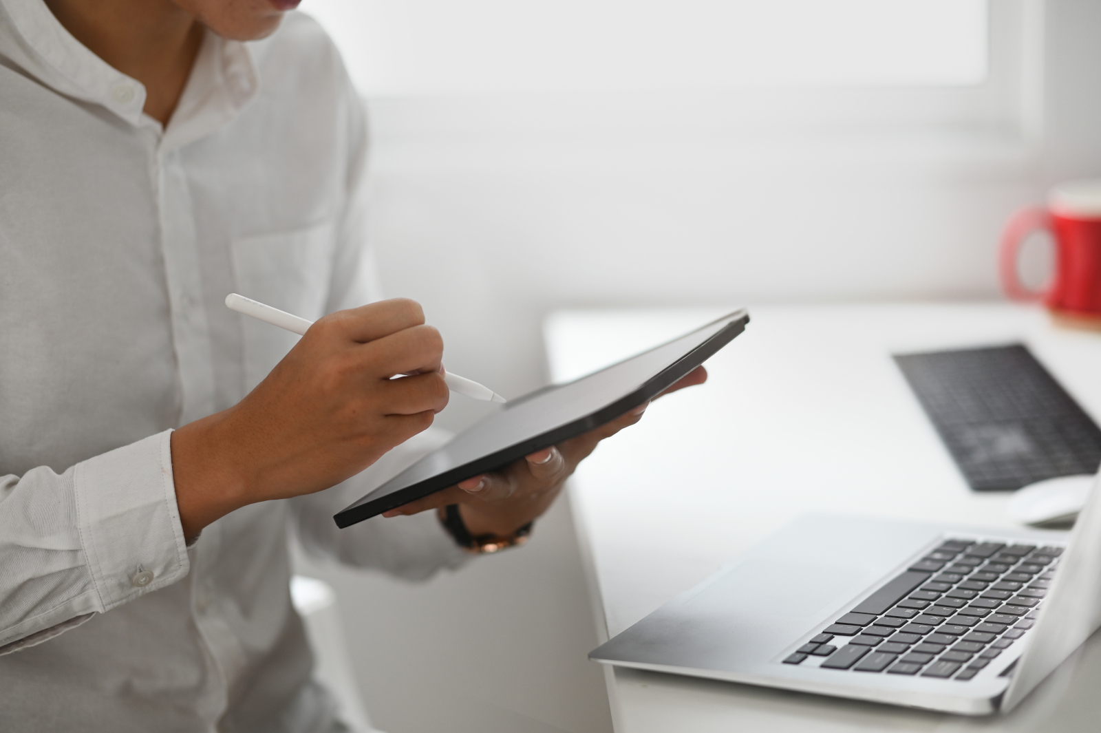 Person with laptop and smart device testing out a new mobile form feature within the NestForms offline survey app platform 