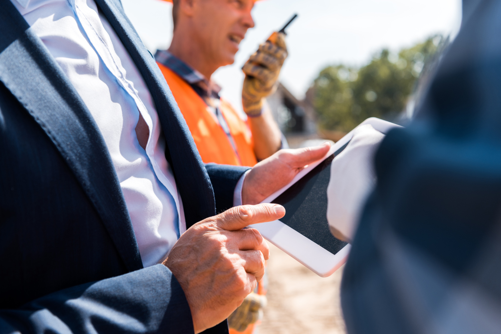 Construction project managers on the ground with tablet: NestForms Project Management Form and Project Completion Reports