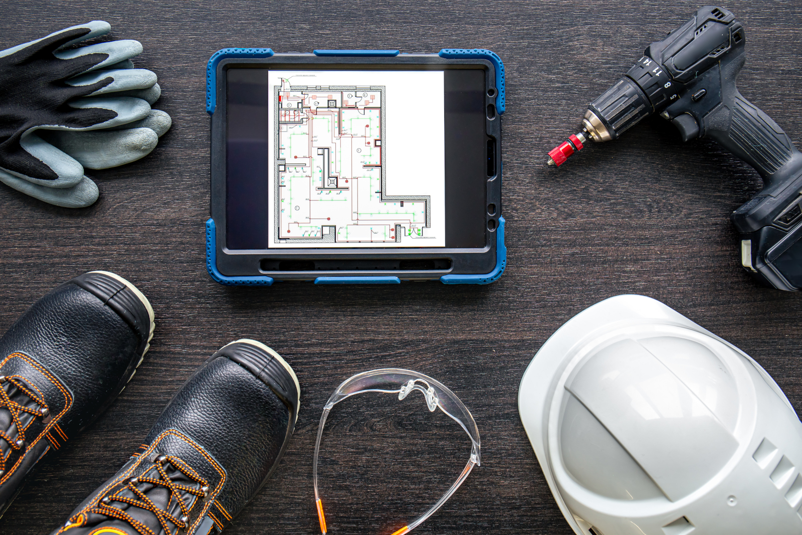 Concept image of smart device and construction safety gear sitting on a table: The NestForms snagging list survey app