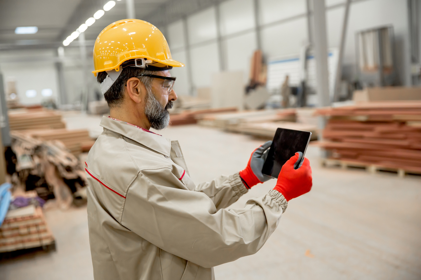 Warehouse worker using tablet within a timber manufacturing facility: the NestForms Quality Control App