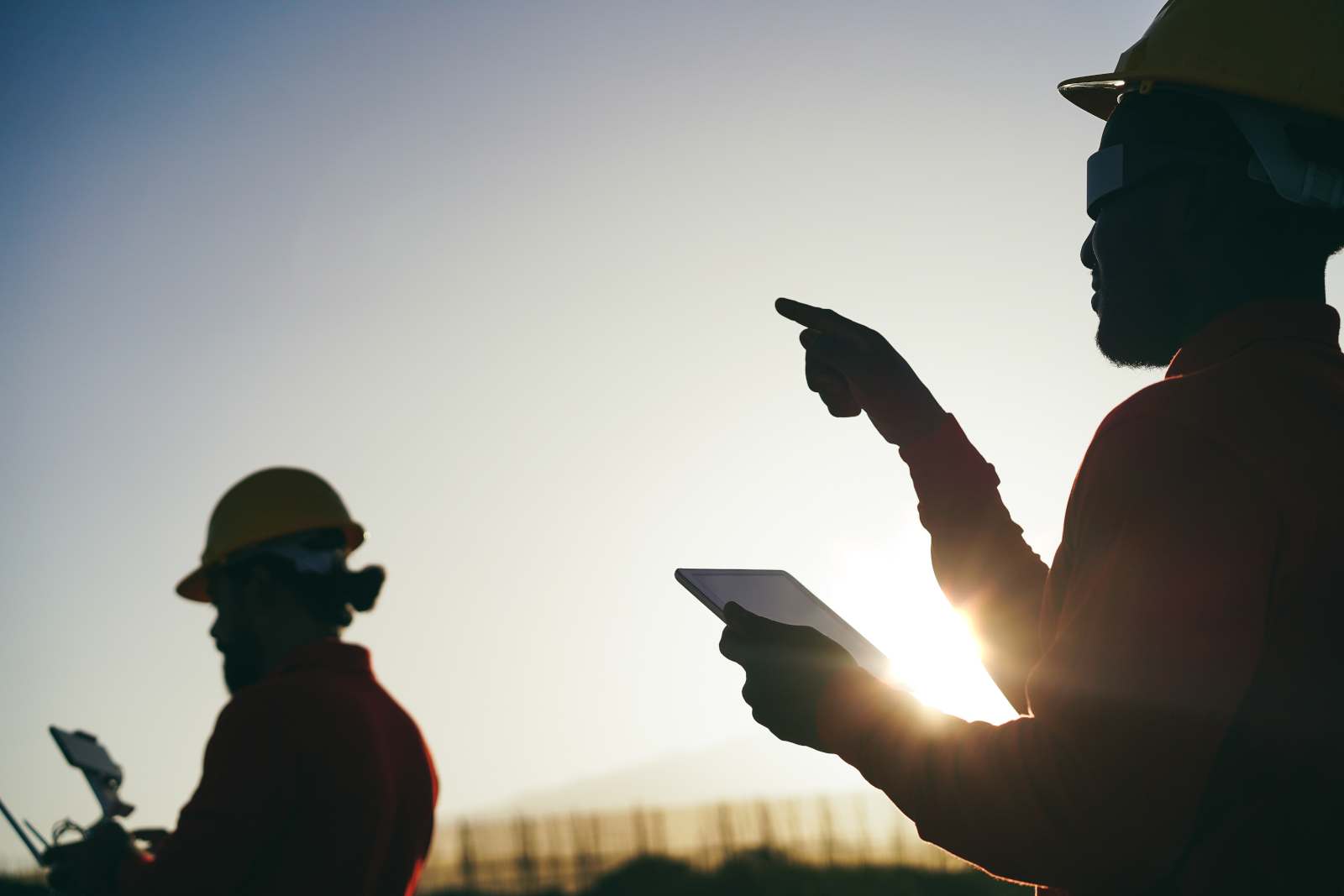 Two surveyors in the field with smart device using the NestForms GPS Land survey app to complete a project handover checklist