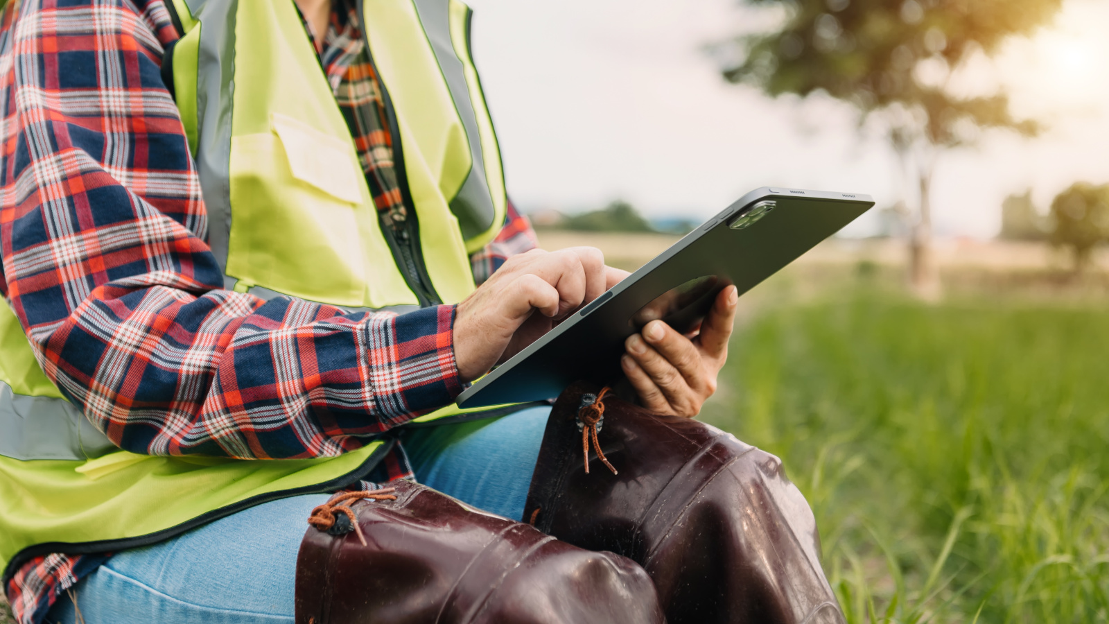Agricultural worker in hi-vis vest with smart device working offline in rural setting: The NestForms GPS Survey App