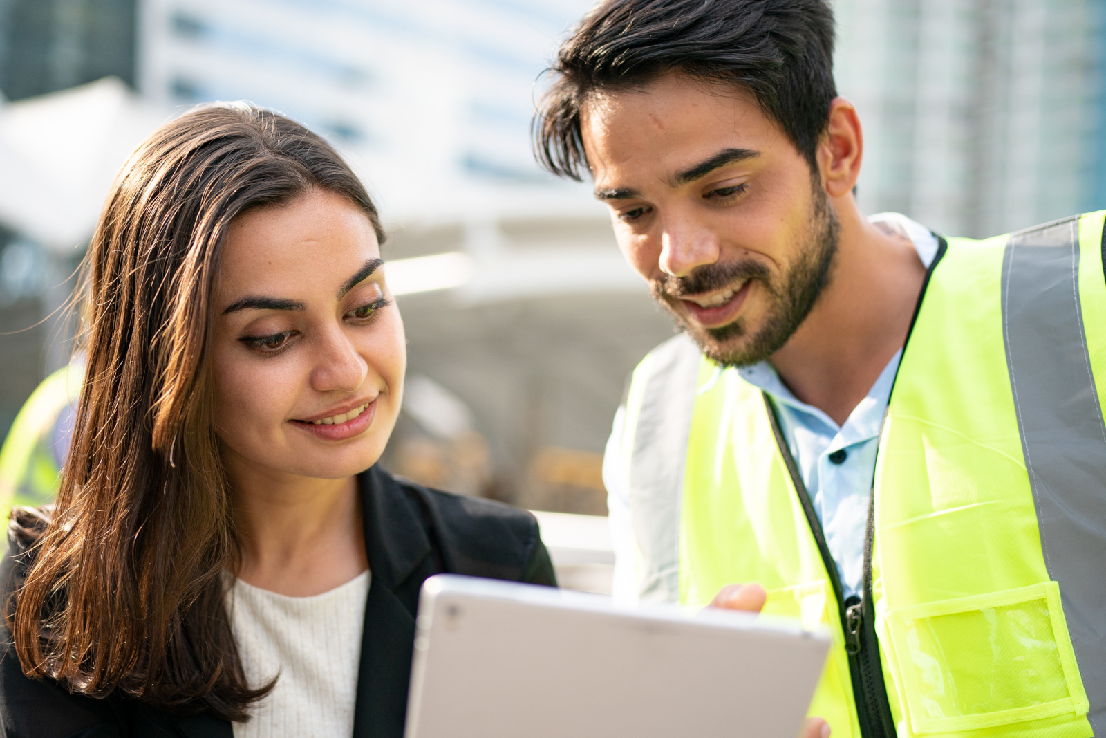 Project manager in hi-vis vest and client with tablet: Client Sign Off with the NestForms field service management software