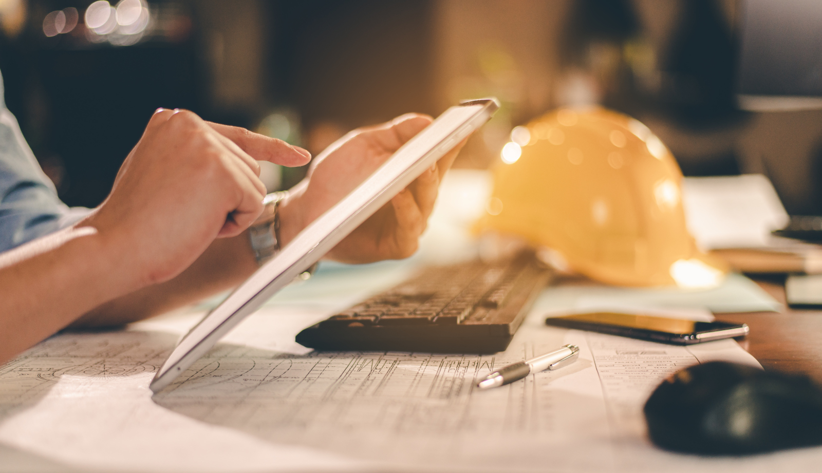Male architect at desk using smart device documenting project management phases: Project Handover Checklist