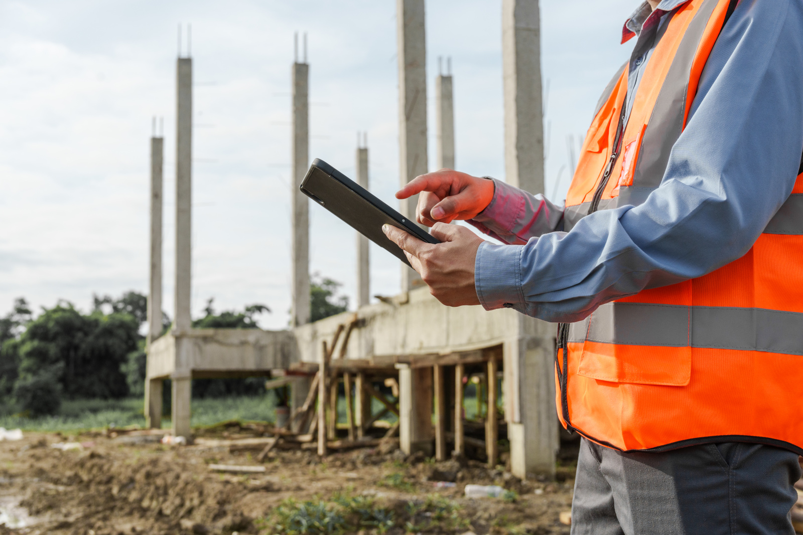Surveyor onsite in hi-vis vest and holding a tablet working on an inspection form: The NestForms offline survey app