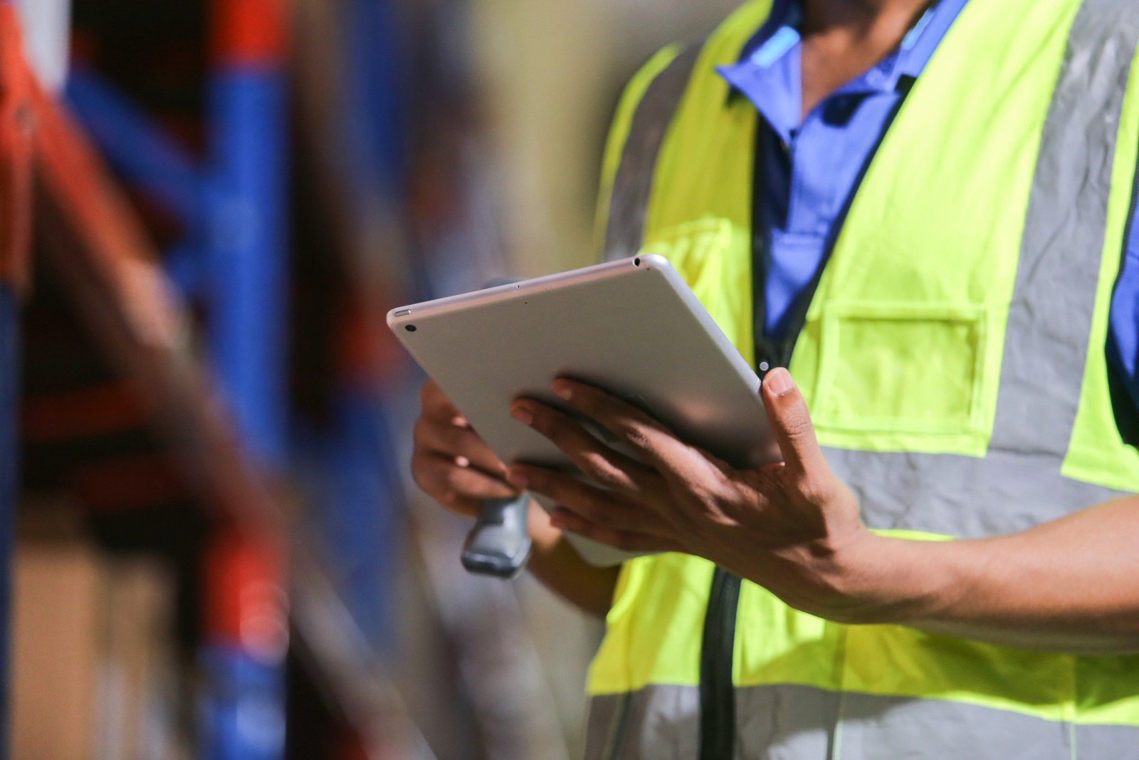 Construction worker in hi-vis safety wear holding tablet: Project Tracking Forms with the NestForms field management system 