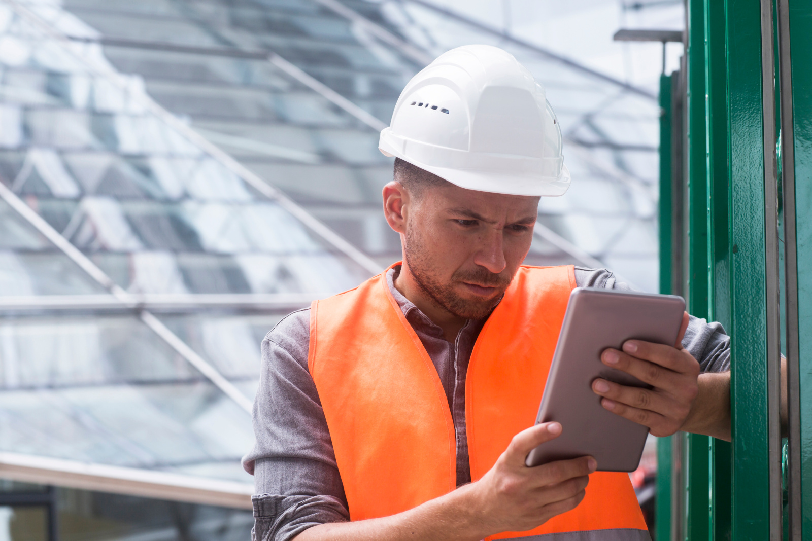 Construction worker with tablet wearing hi-vis vest and safety helmet: Checklists with the NestForms Punch List App