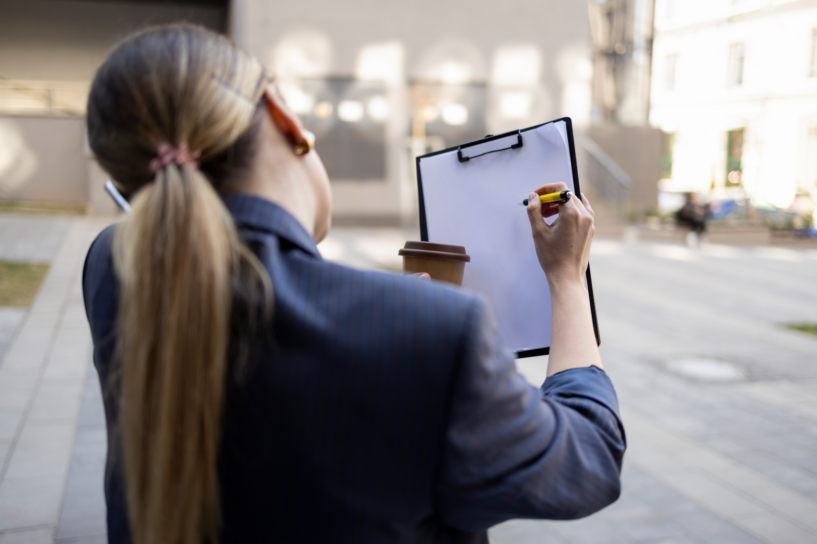 Woman completing survey in factory, on clipboard using pen and paper:  Nestforms offline surveys