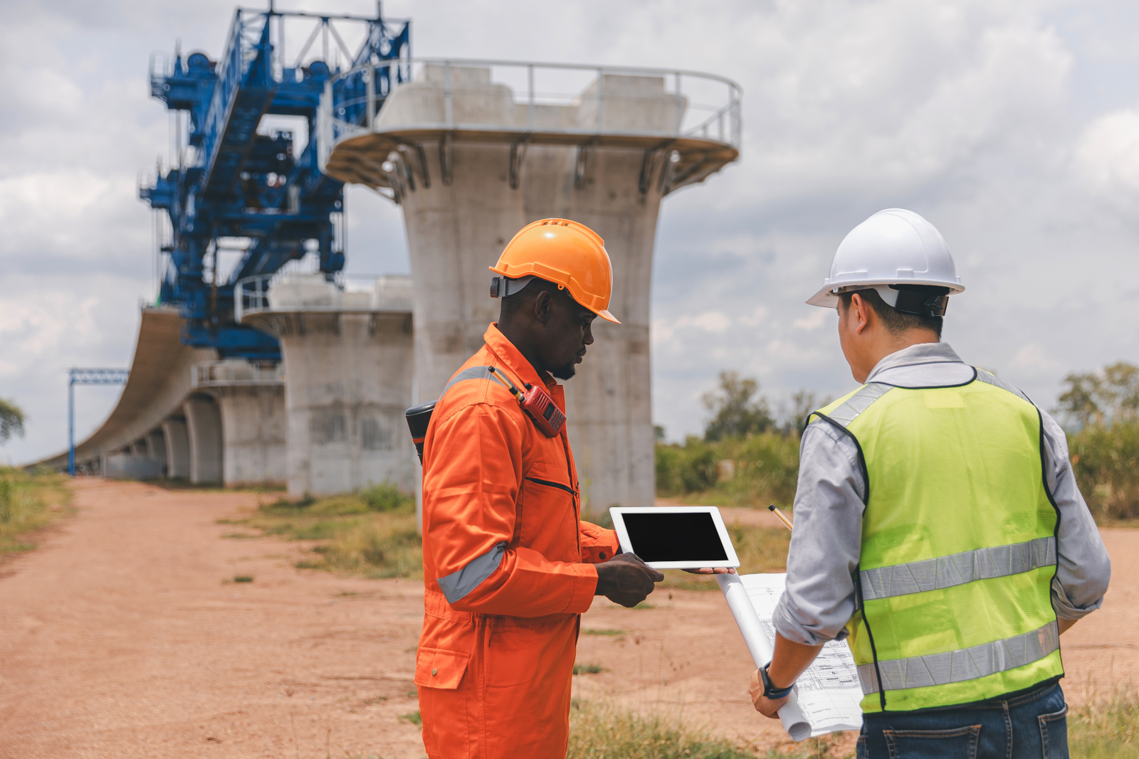 Engineer and surveyor with smart device standing in front of a new bridge construction project: NestForms Site Handover Form