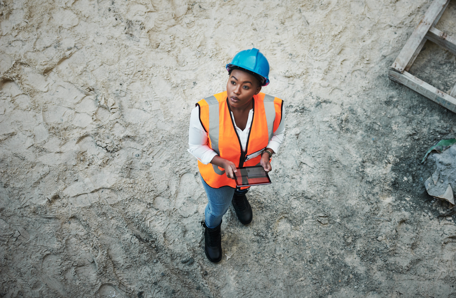 Female surveyor with tablet looking up and working on a Final Inspection Checklist: NestForms mobile data collection app