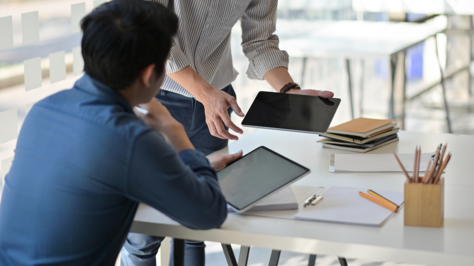 Two Project managers, each holding a tablet at desk: Project Handover Checklists with the NestForms mobile form app 