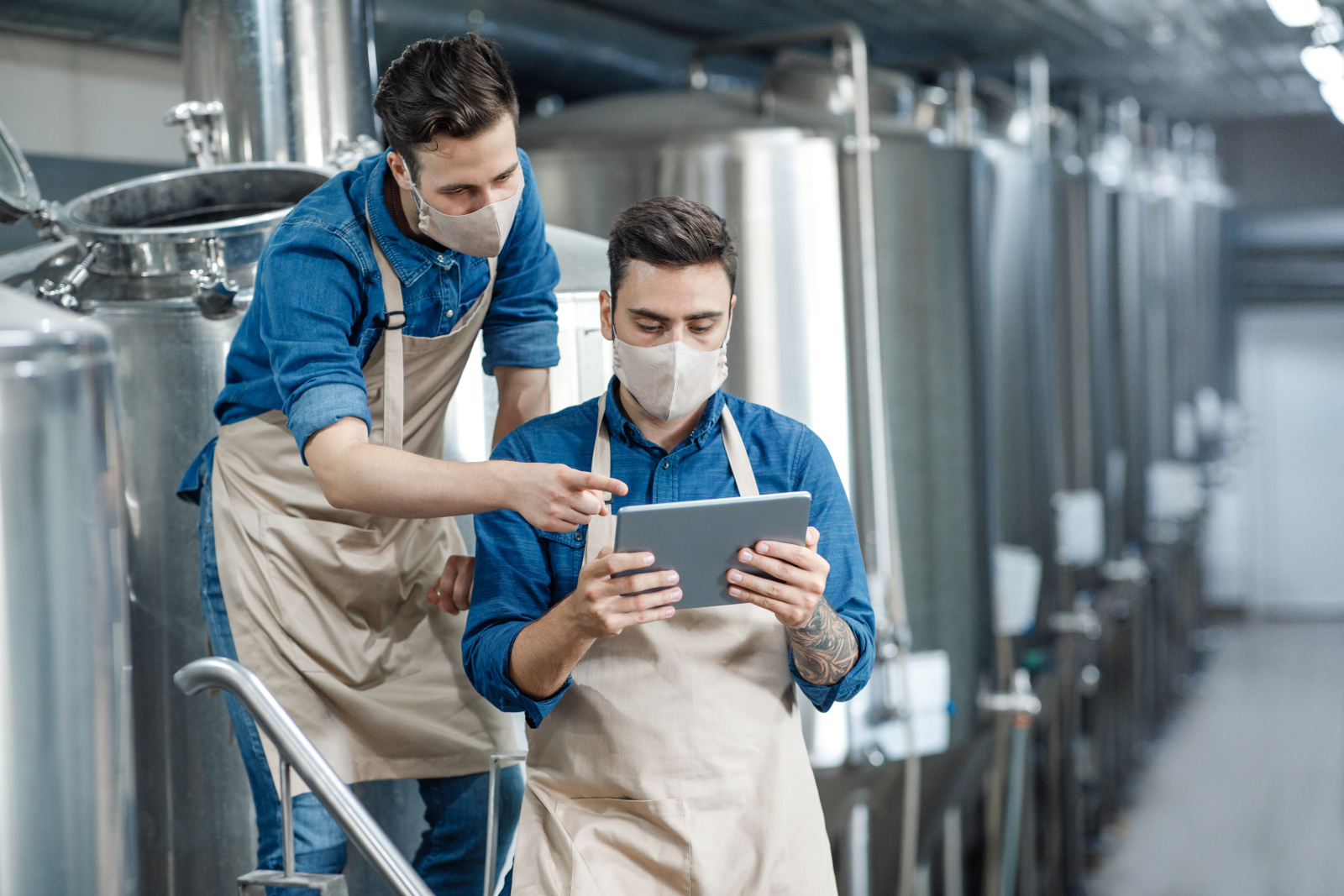 Two male Quality Control inspectors at brewery factory location with tablet: The NestForms field service management softwareWhy most teams fix the wrong thing