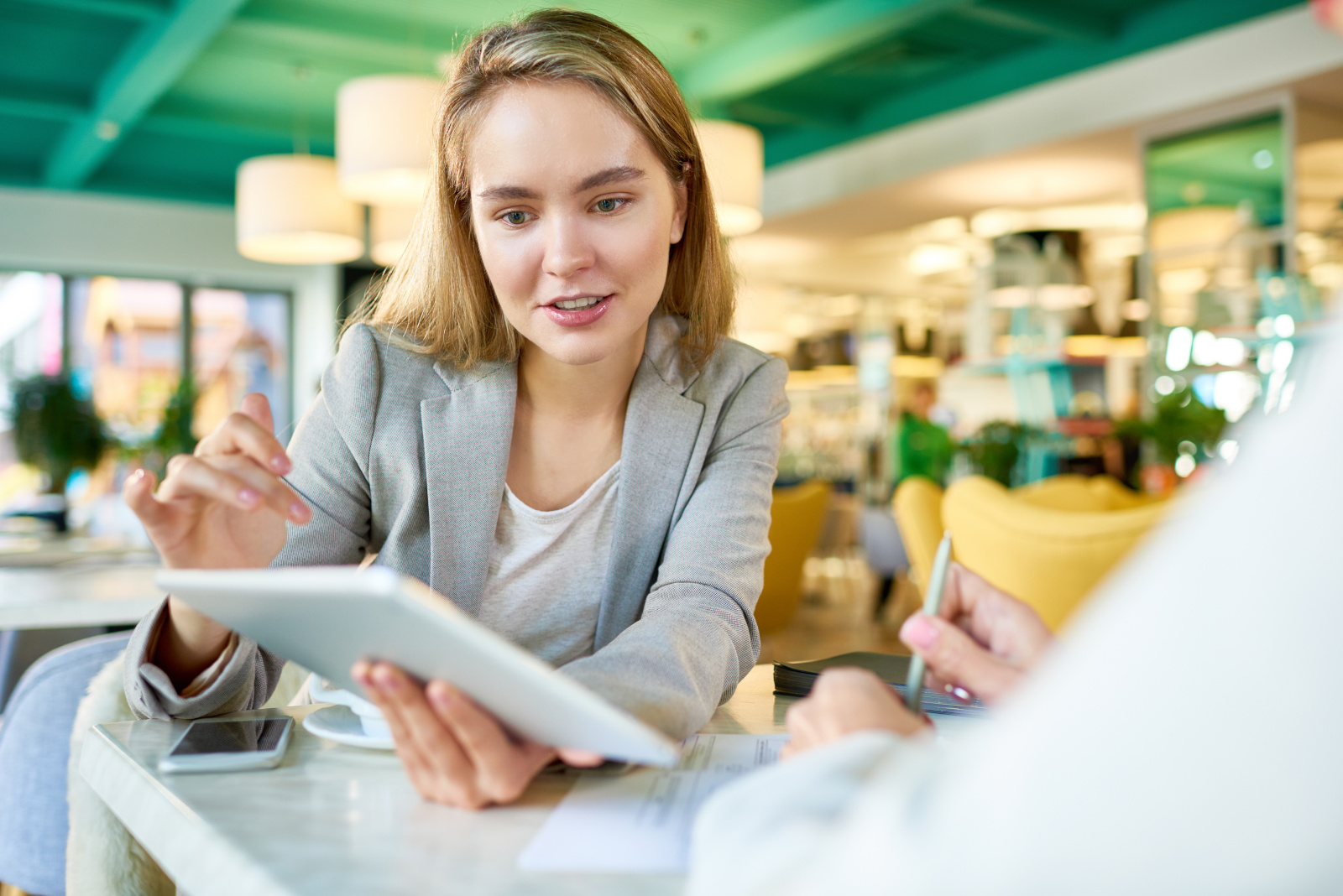 Female event promotion organiser interviewing a customer with tablet instore: NestForms Market Research Surveys