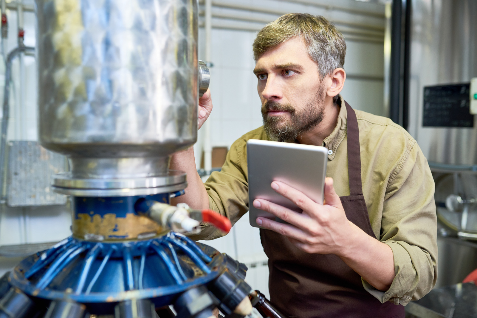 Engineer with tablet carrying out final inspection checklist on machinery installation: Using the NestForms mobile form app
