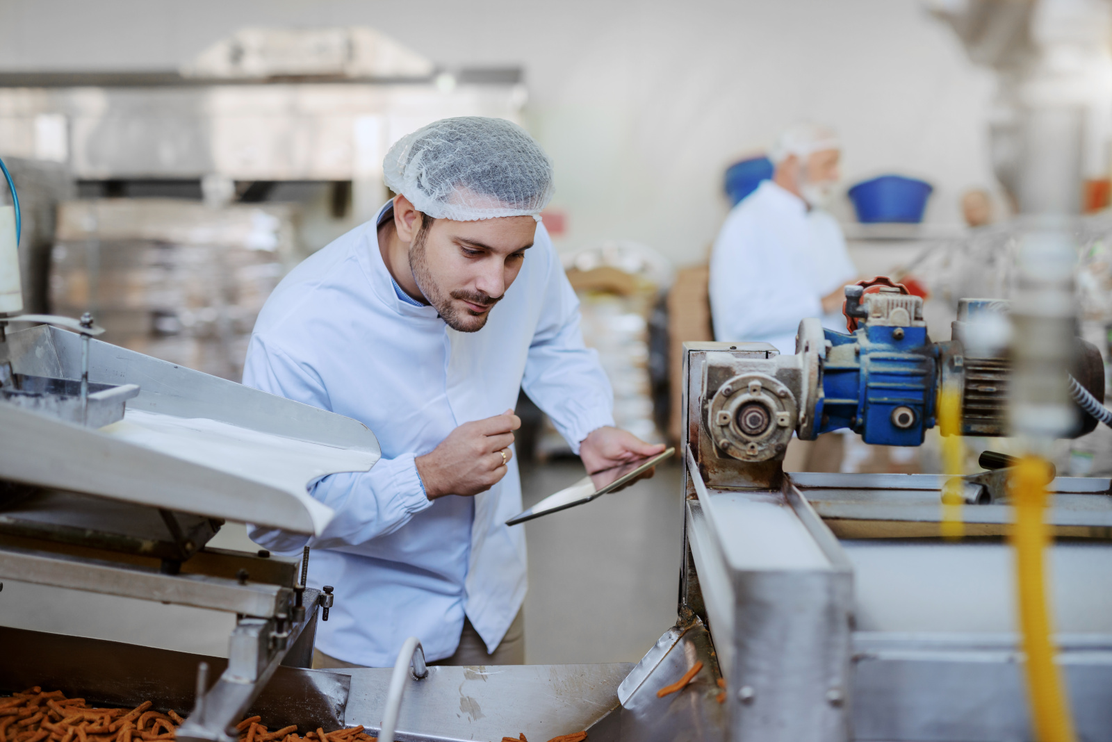 Food production Quality Control inspector with smart device working on a Final Inspection Checklist Form