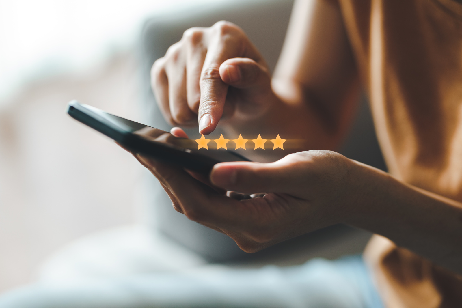 Person with smartphone showing an example of a visual rating scale (stars) used for Market Research Surveys